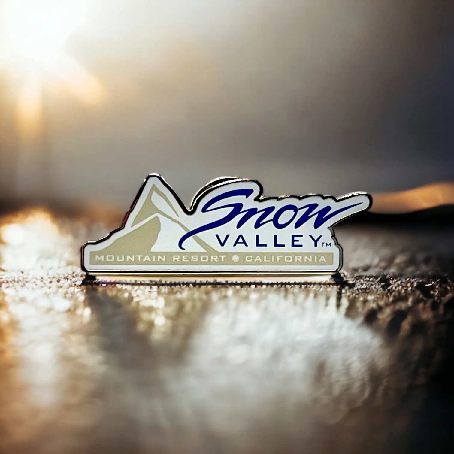 Snow Valley pin with Snow Valley font in blue and a mountain with Mountain Resort, California font in white/khaki